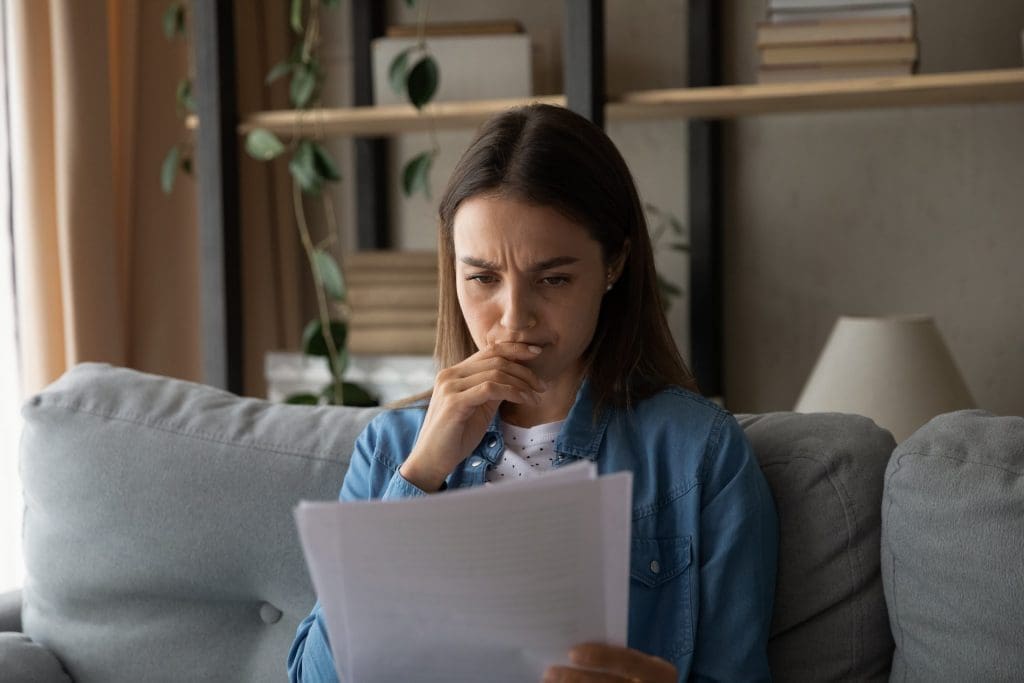 stressed female reading rejection letter